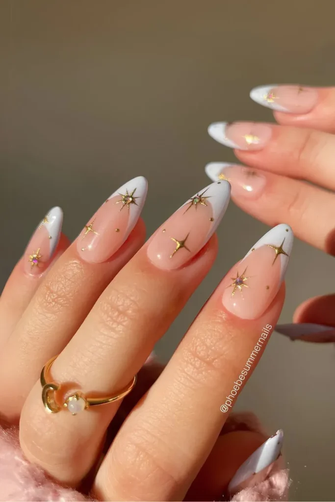 White French tip manicure with celestial star and moon accents